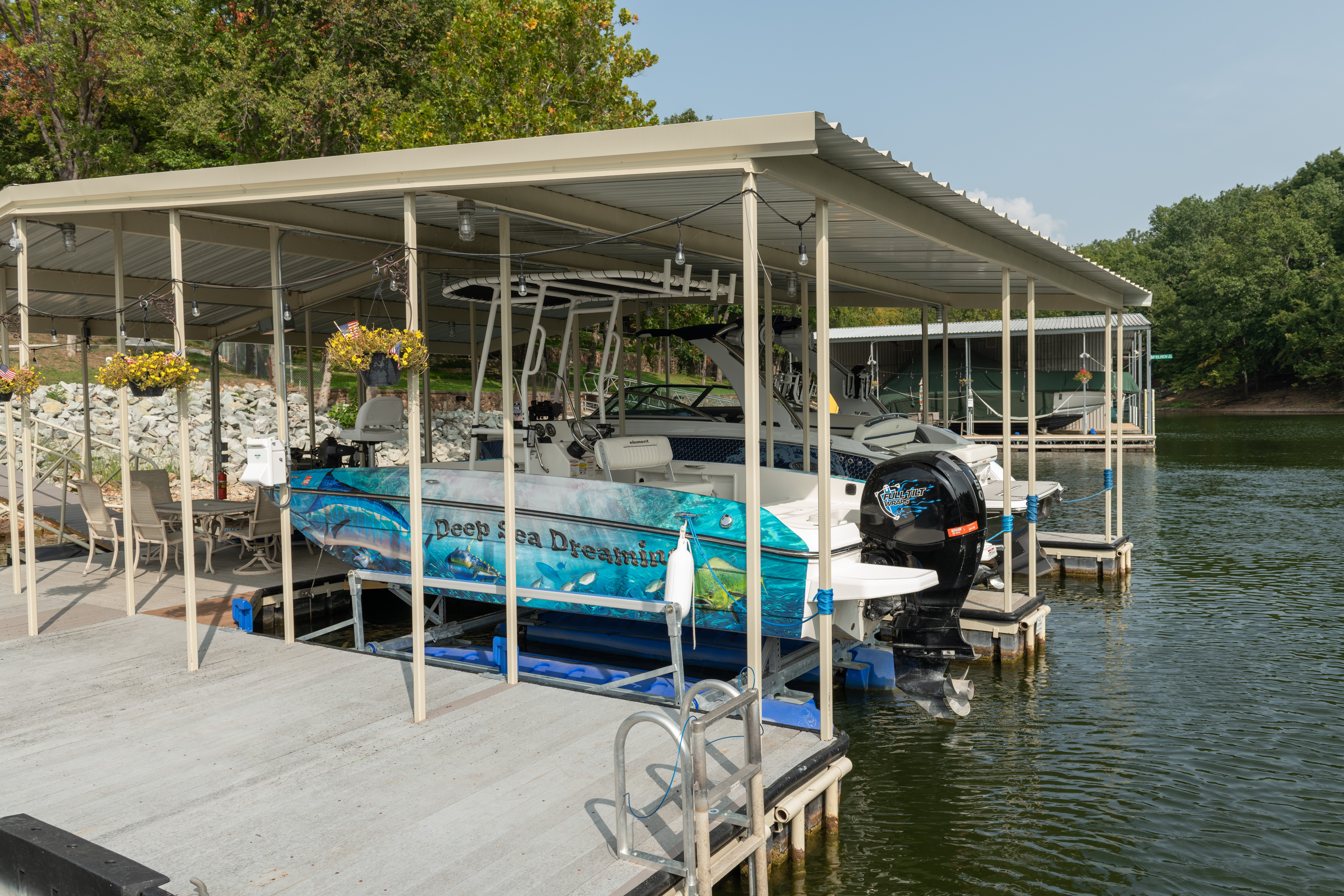 Motorboat stored under a covered dock on a lake with waterfront marina slips