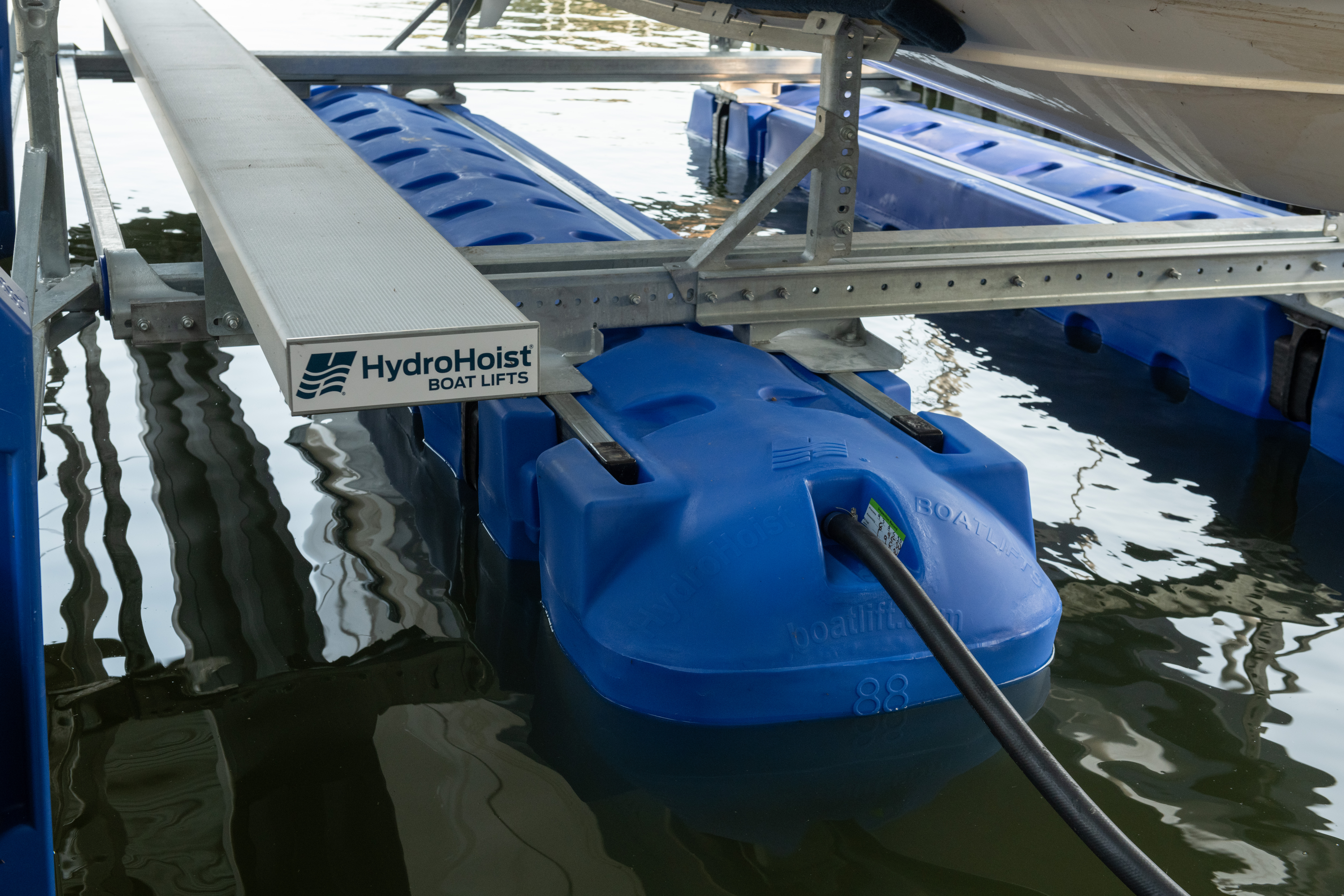 HydroHoist floating boat lift installed beneath a dock, supporting a boat above the water.