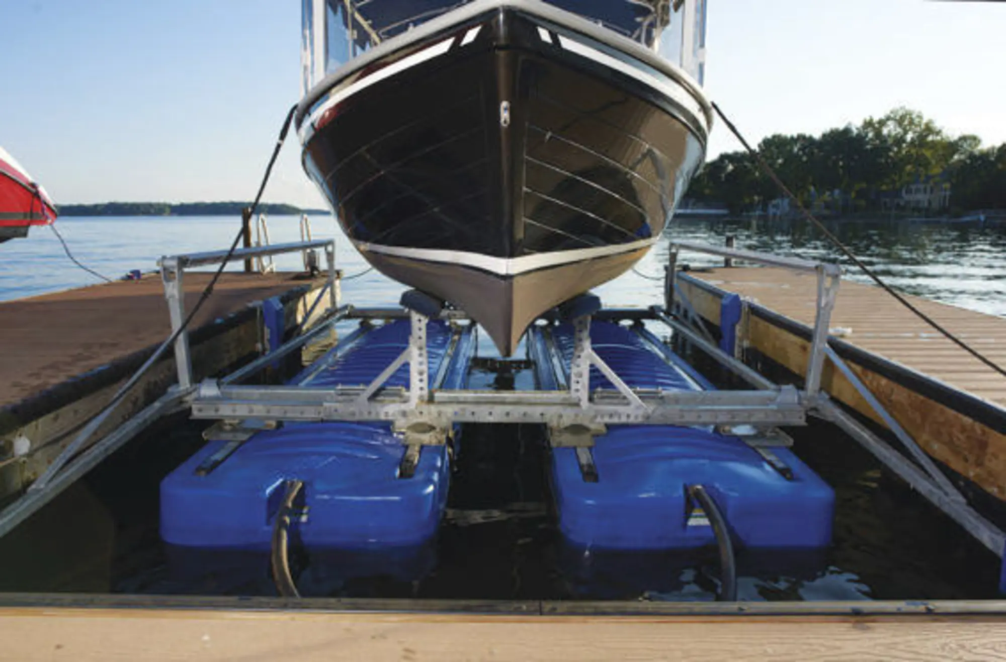 Boat stored above the water on a HydroHoist boat lift in a covered slip